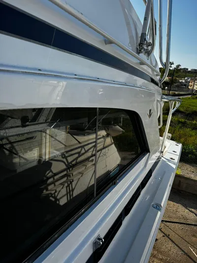 Three Wishes Yacht Photos Pics Side view of a 2000 Bertram 36 SF yacht, showcasing sleek design and window details.