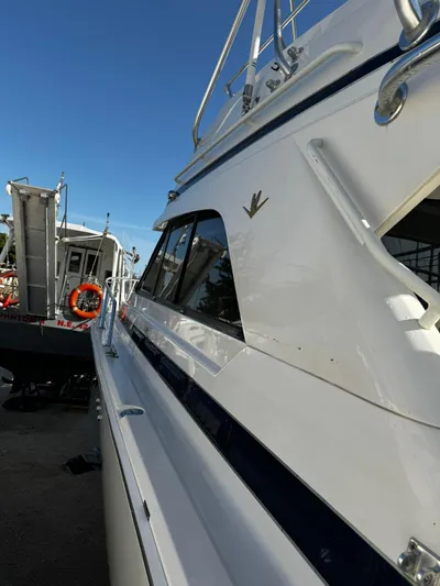 Three Wishes Yacht Photos Pics Side view of a 2000 Bertram 36 SF boat docked under a clear blue sky.