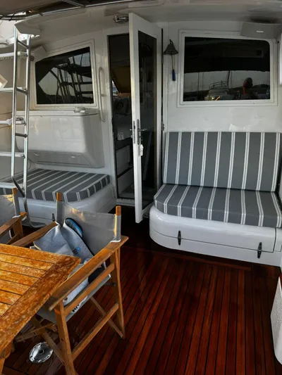 Three Wishes Yacht Photos Pics Bertram 36 SF 2000 yacht interior with striped seating and wooden flooring.