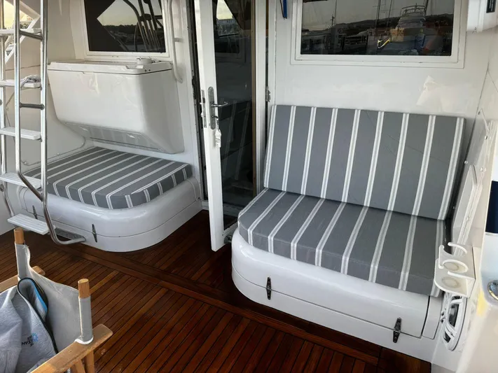 Three Wishes Yacht Photos Pics Bertram 36 SF 2000 boat interior with striped cushions and wooden flooring.
