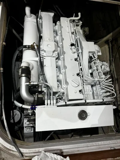 Three Wishes Yacht Photos Pics Engine compartment of a 2000 Bertram 36 SF boat, showcasing a clean, white-painted engine.