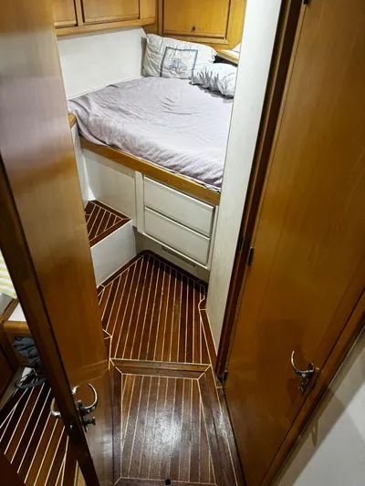 Three Wishes Yacht Photos Pics Bertram 36 SF 2000 cabin interior with wooden flooring and cozy bed.