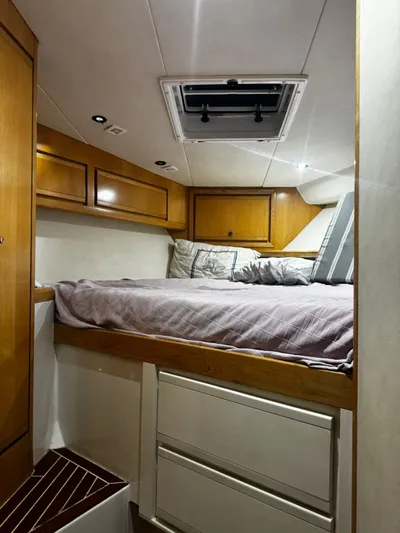 Three Wishes Yacht Photos Pics Cozy cabin interior of 2000 Bertram 36 SF with wooden cabinets and comfortable bedding.