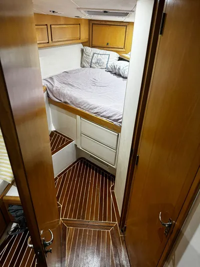 Three Wishes Yacht Photos Pics Cozy cabin interior of 2000 Bertram 36 SF with wood flooring and bed.