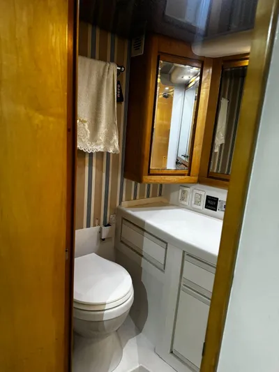 Three Wishes Yacht Photos Pics Bathroom interior of 2000 Bertram 36 SF yacht with wood accents and striped wallpaper.