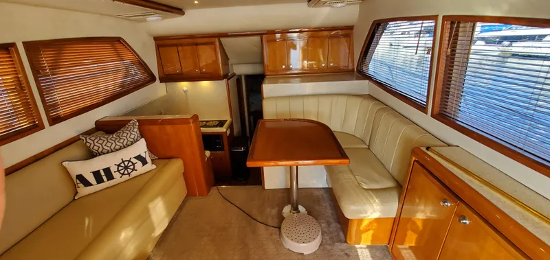 Mai Time Yacht Photos Pics Interior of 2001 Bertram 390 Convertible yacht with wooden cabinetry and beige seating.