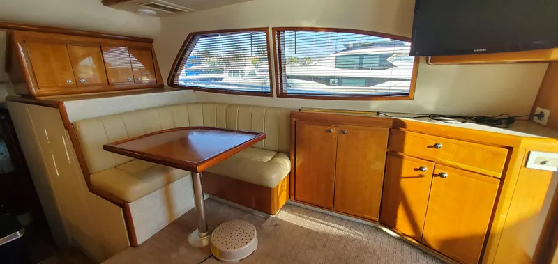 Mai Time Yacht Photos Pics Interior of 2001 Bertram 390 Convertible yacht with dining area and wooden cabinetry.