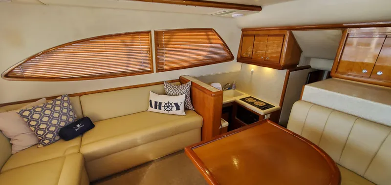 Mai Time Yacht Photos Pics Interior of 2001 Bertram 390 Convertible yacht with beige seating and wooden accents.