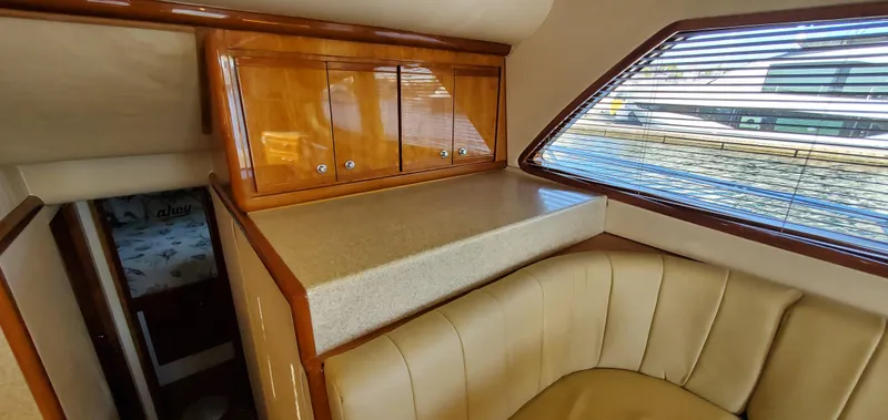 Mai Time Yacht Photos Pics Interior of 2001 Bertram 390 Convertible yacht with wood cabinets and leather seating.