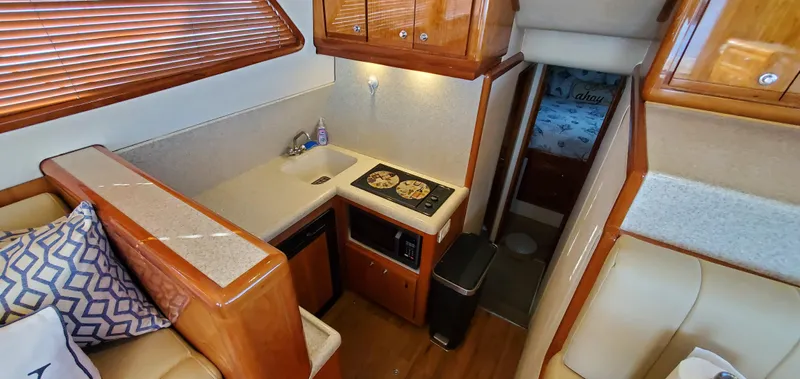 Mai Time Yacht Photos Pics Interior of 2001 Bertram 390 Convertible yacht, featuring kitchen area with stove and sink.