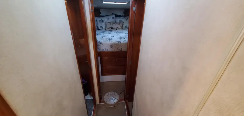Mai Time Yacht Photos Pics Narrow hallway leading to a cozy bedroom on a 2001 Bertram 390 Convertible boat.
