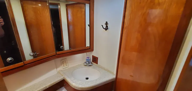 Mai Time Yacht Photos Pics 2001 Bertram 390 Convertible bathroom with wooden cabinets and a white sink.