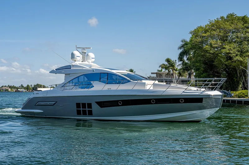  Yacht Photos Pics 2014 Azimut 55S yacht cruising on a sunny day, surrounded by lush greenery.