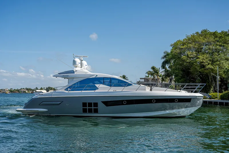  Yacht Photos Pics 2014 Azimut 55S yacht cruising on a sunny day, surrounded by lush greenery.