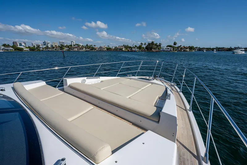  Yacht Photos Pics 2014 Azimut 55S yacht with sun loungers on deck, overlooking serene waters and distant skyline.