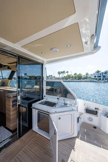  Yacht Photos Pics 2014 Azimut 55S yacht deck with outdoor kitchen, overlooking serene waterfront.