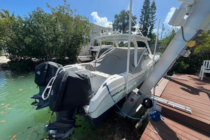  Yacht Photos Pics 2020 World Cat 296 DC boat docked with covered engines and lush greenery.