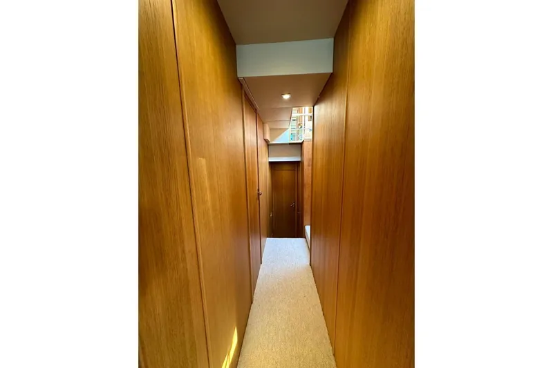  Yacht Photos Pics Narrow wooden hallway inside 2014 Fairline Squadron 65 yacht, featuring sleek design and modern lighting.