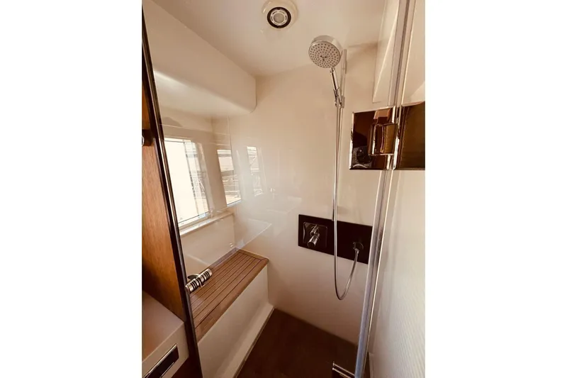  Yacht Photos Pics Luxurious shower area in 2014 Fairline Squadron 65 yacht, featuring modern fixtures and wooden bench.