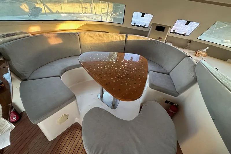  Yacht Photos Pics Interior of 1998 Fountaine Pajot Bahia 46 catamaran with curved seating and wooden table.
