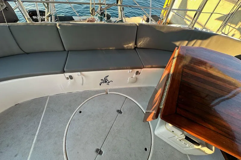  Yacht Photos Pics 1998 Fountaine Pajot Bahia 46 yacht cockpit with cushioned seating and wooden table.