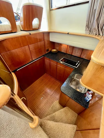 Way To Go Yacht Photos Pics 1999 Viking Sport Cruisers 60 Flybridge kitchen with wood cabinetry and compact design.