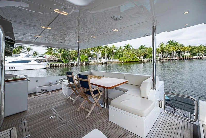 Lucky 7 Yacht Photos Pics Luxurious 2017 Azimut 80 yacht deck with seating, overlooking serene waterfront and palm trees.