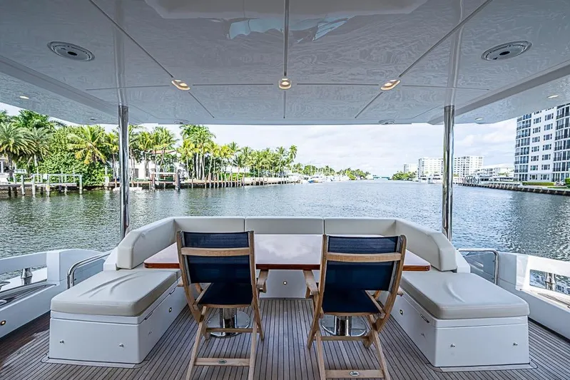 Lucky 7 Yacht Photos Pics Luxurious 2017 Azimut 80 yacht deck with seating, overlooking serene waterfront and palm trees.