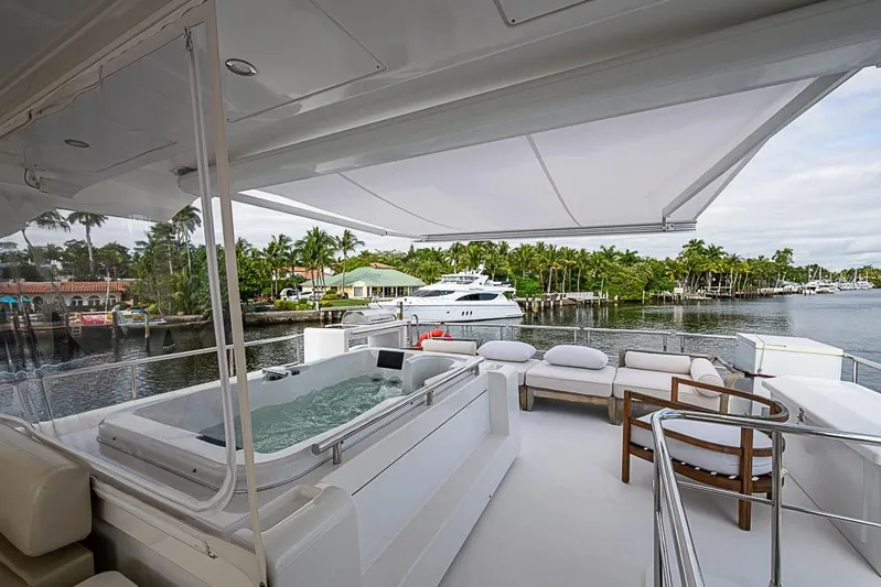 Lucky 7 Yacht Photos Pics Luxurious 2017 Azimut 80 yacht deck with jacuzzi and seating area, overlooking serene waterfront.