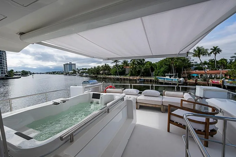 Lucky 7 Yacht Photos Pics Luxurious 2017 Azimut 80 yacht deck with jacuzzi and seating, overlooking scenic waterfront.