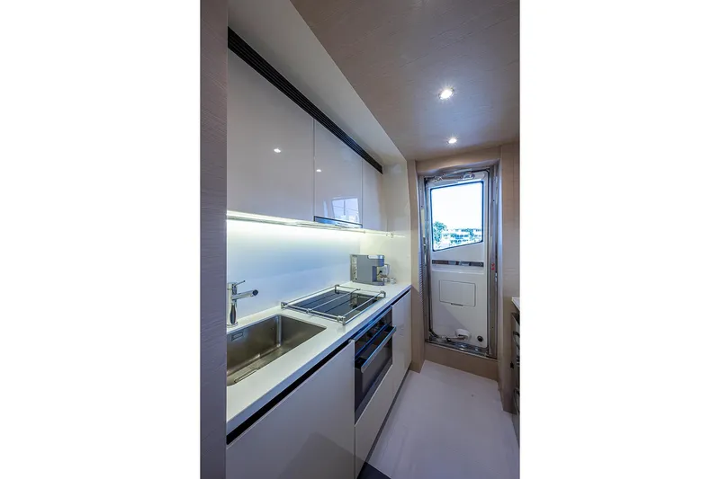 Lucky 7 Yacht Photos Pics Modern kitchen interior on 2017 Azimut 80 yacht, featuring sleek cabinetry and stainless steel appliances.