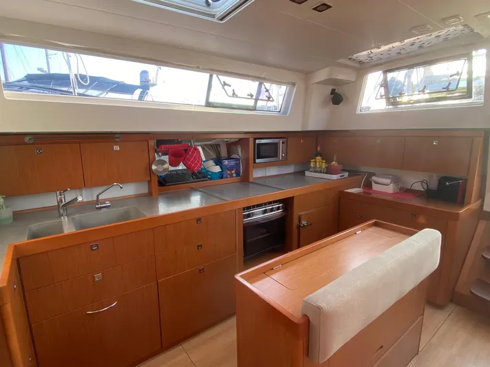  Yacht Photos Pics Interior of 2014 Beneteau Sense 50 yacht kitchen with wooden cabinetry and modern appliances.