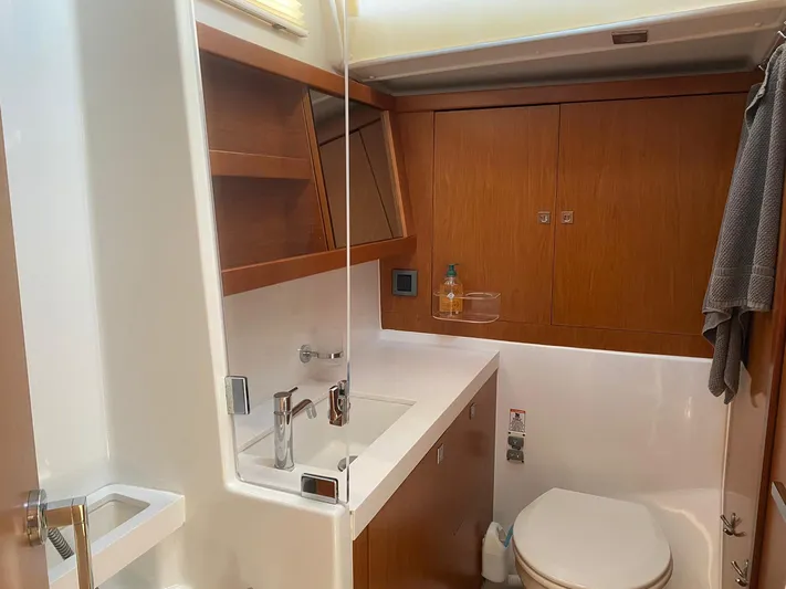  Yacht Photos Pics 2014 Beneteau Sense 50 yacht bathroom with modern fixtures and wooden cabinetry.