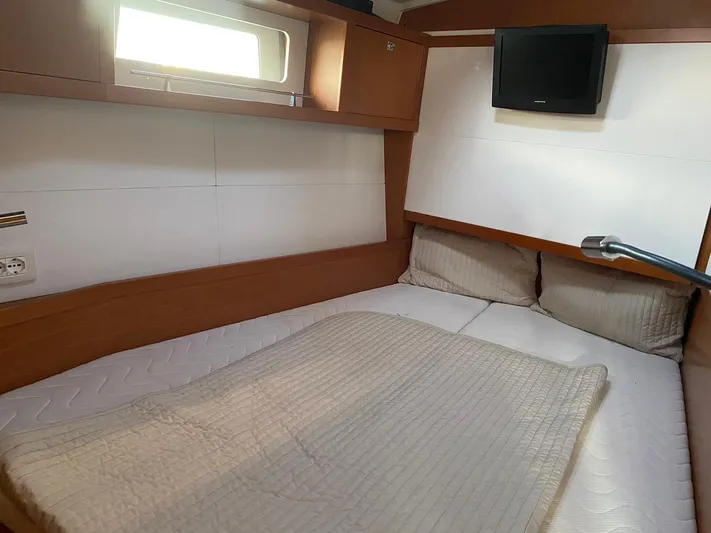  Yacht Photos Pics 2014 Beneteau Sense 50 cabin with bed, window, and mounted TV.
