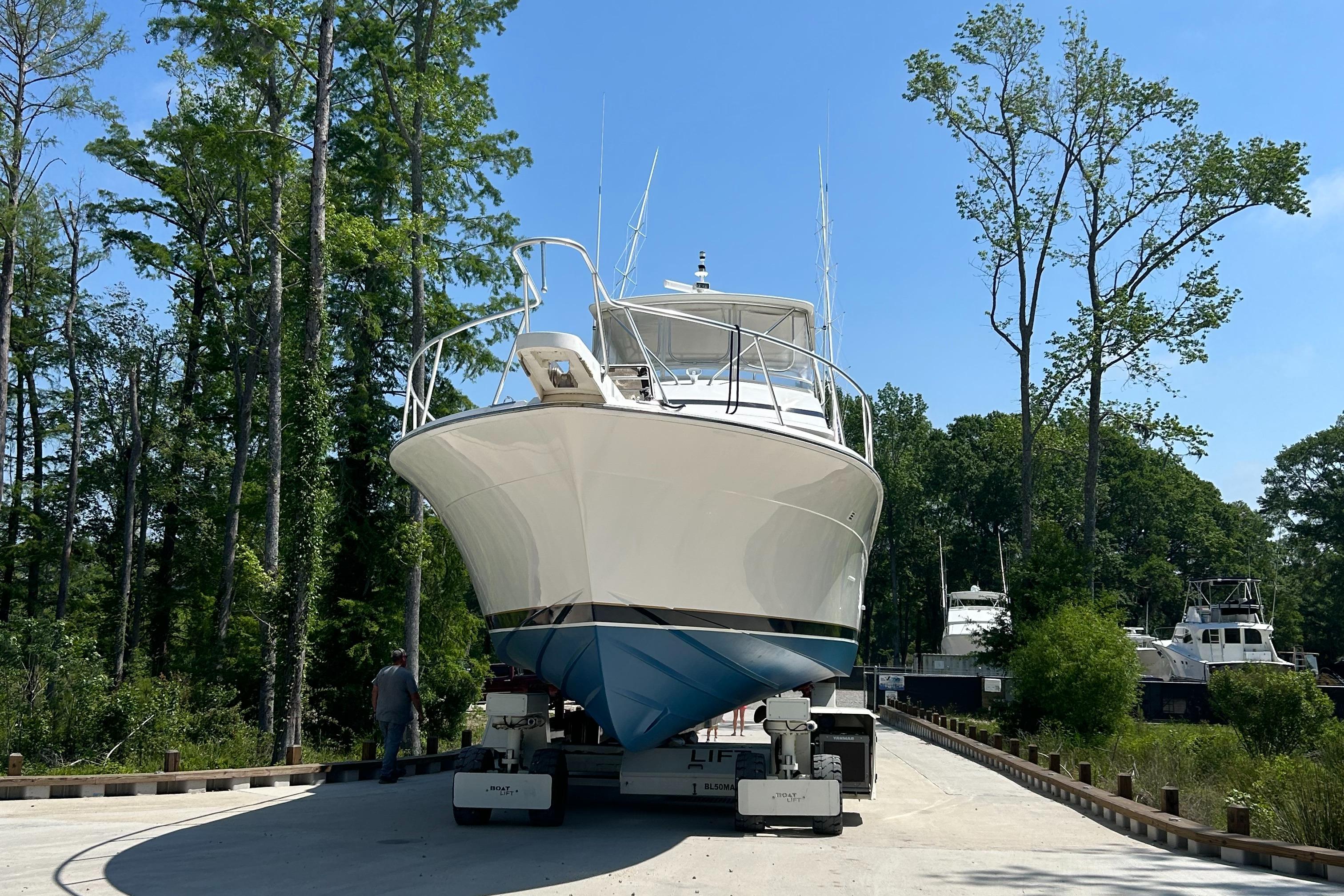 1999 Bertram 60 Convertible yacht on a trailer in a marina.