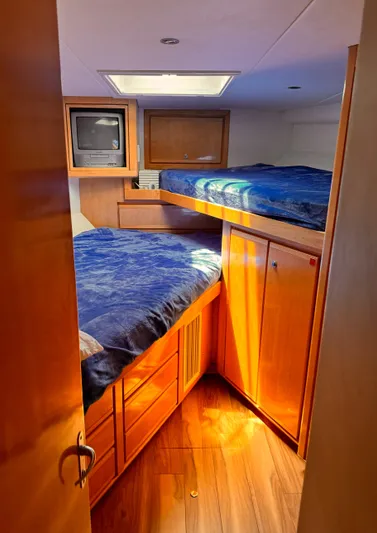 Satisfaction Yacht Photos Pics Cozy cabin interior of a 1999 Bertram 60 Convertible yacht with wooden furnishings.