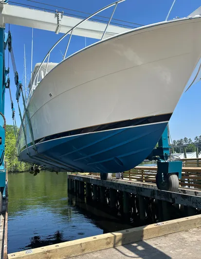 Satisfaction Yacht Photos Pics 1999 Bertram 60 Convertible boat being lifted out of the water.