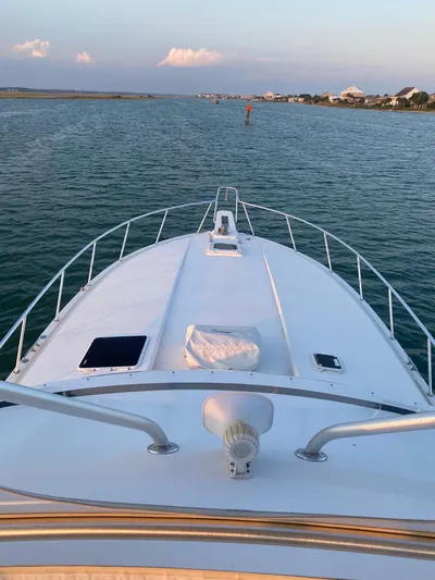 Satisfaction Yacht Photos Pics 1999 Bertram 60 Convertible yacht cruising on calm waters.