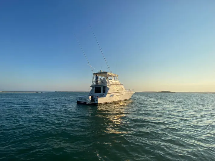 Satisfaction Yacht Photos Pics 1999 Bertram 60 Convertible yacht on open water at sunset.