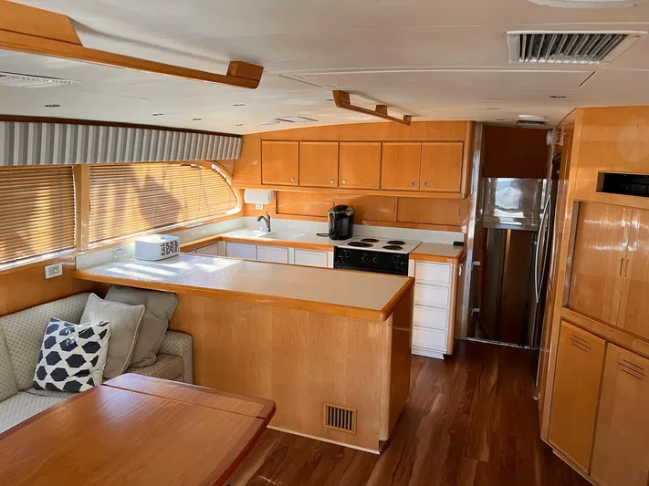 Satisfaction Yacht Photos Pics Interior of a 1999 Bertram 60 Convertible yacht with modern kitchen and seating area.
