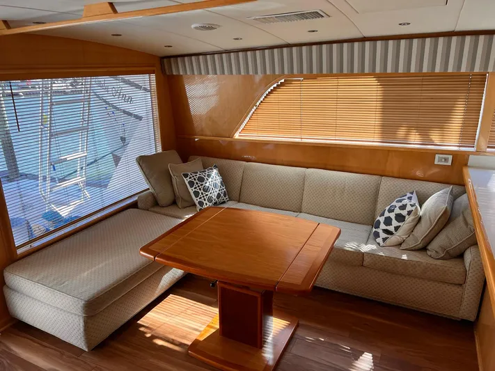 Satisfaction Yacht Photos Pics Interior of 1999 Bertram 60 Convertible yacht with cozy seating and wooden table.
