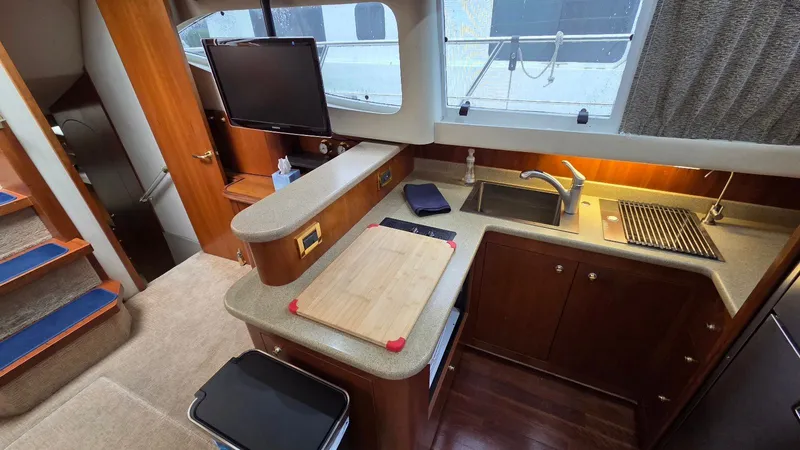 Always Friday Yacht Photos Pics Interior of 2000 Cruisers Yachts 4450 Express Motoryacht, kitchen with wood accents.