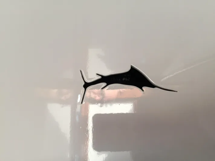 Uncle Jack Yacht Photos Pics 1965 Rybovich 37 Sportfish marlin emblem on glossy white surface.