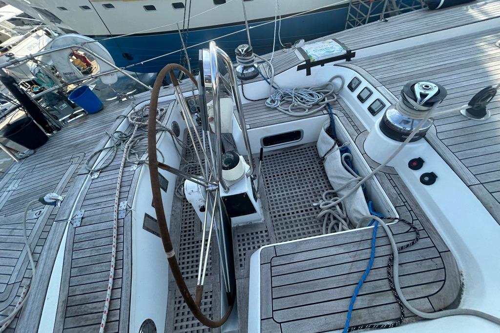 Cockpit of 2000 Comar Comet 65 S yacht with wooden steering wheel and deck.