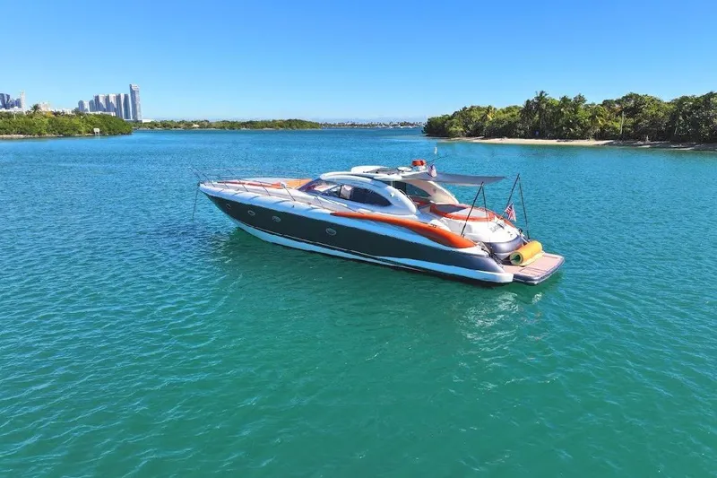  Yacht Photos Pics Sunseeker Predator 60 yacht from 2000 on clear blue water near lush island.