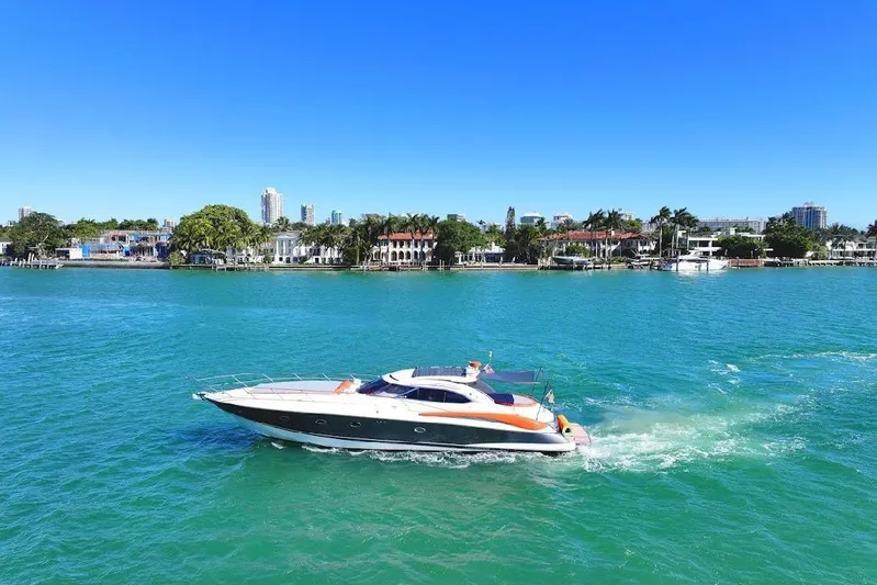  Yacht Photos Pics Sunseeker Predator 60 yacht cruising on turquoise waters, 2000 model, with scenic coastal backdrop.
