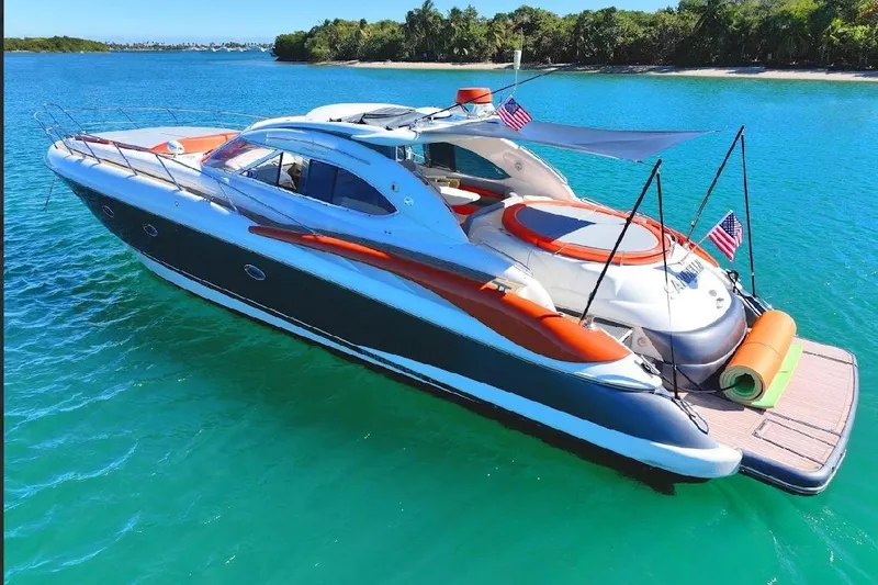  Yacht Photos Pics Luxurious 2000 Sunseeker Predator 60 yacht on turquoise water, featuring sleek design and vibrant accents.