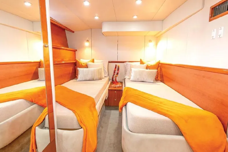  Yacht Photos Pics Luxurious twin cabin in 2000 Sunseeker Predator 60 yacht with warm lighting and orange accents.