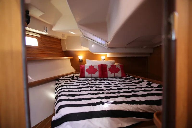 Platypus Yacht Photos Pics Cozy cabin interior of 2014 Catalina 445 sailboat with striped bedding and maple leaf pillows.