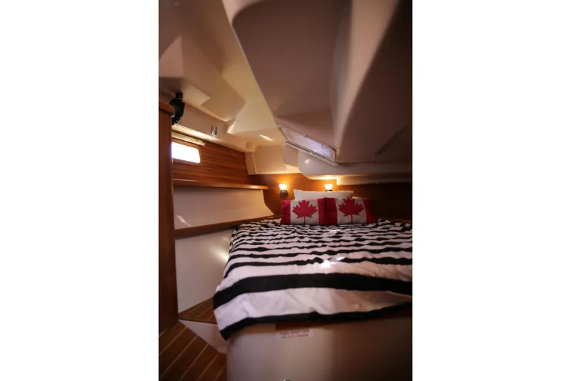 Platypus Yacht Photos Pics Cozy cabin interior of 2014 Catalina 445 sailboat with striped bedding and maple leaf pillows.